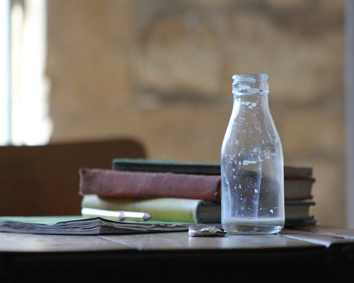 A closed notebook beside a bottle of water on a desk highlighting healthy study habits