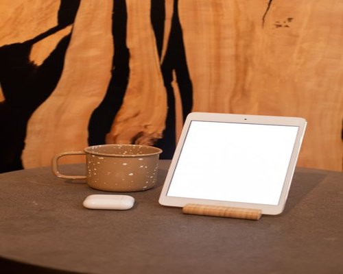 A desk setup featuring a digital tablet and a ceramic coffee mug inside a modern building in Monterrey
